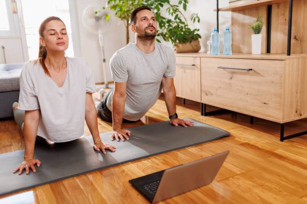 istock Couple doing online yoga training course 1388250478