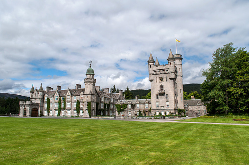Balmoral Castle is the summer residence of the British Queen in Scotland. Old stone castle with several towers and a large garden.