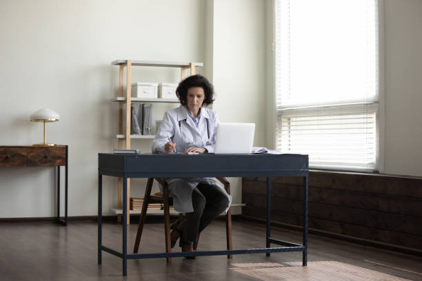 istock Focused serious senior head doctor working at hospital office workplace 1388253721
