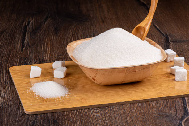 istock White granulated sugar and lump sugar on a cutting board. 1388254074