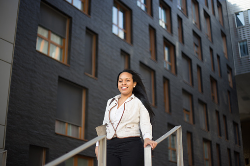 Portrait of a young woman Real Estate Agent or businesswoman standing outdoors on the modern residential district background