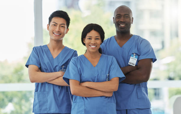 portrait of a group of medical practitioners standing together with their arms crossed in a hospital - hemşire tıbbi personel fotoğraflar stok fotoğraflar ve resimler