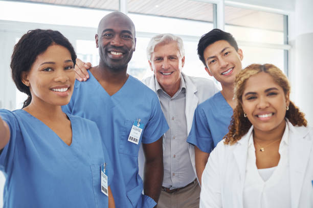 portrait d’un groupe de médecins prenant des selfies ensemble dans un hôpital - healthcare and medicine smiling group of people lab coat photos et images de collection