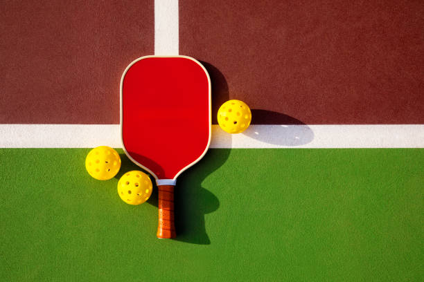 Pickleball Paddle and Balls on a Outdoor Court This is a photograph taken outside of a pickleball paddle and balls on a outdoor court pickleball equipment stock pictures, royalty-free photos & images