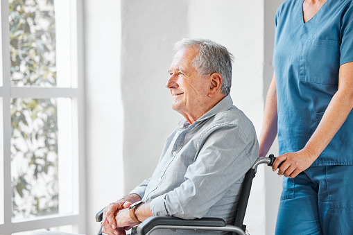A senior man with disabilities talks with a home caregiver