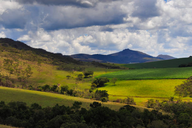 istock clouds casting shadows over a green valley with a cornfield, and in the distant background, the peak of the hawk. 1388262881