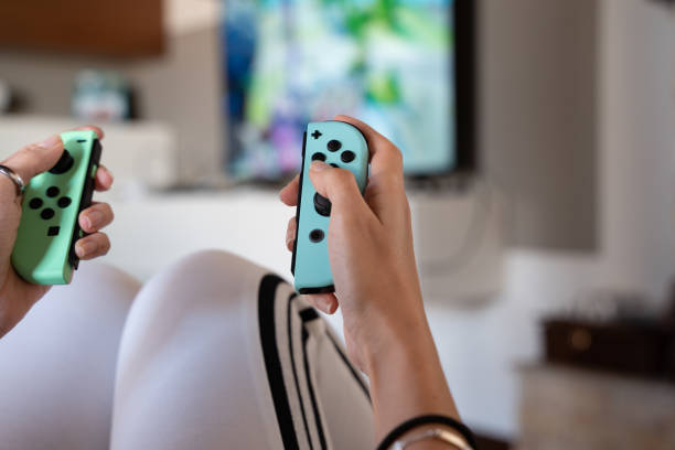 young girl playing at home with nintendo switch special edition - selective focus - edition imagens e fotografias de stock