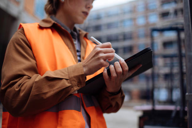 technology makes her work easier - building contractor engineer digital tablet construction imagens e fotografias de stock