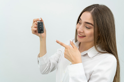 Woman with a car keys. Isolated on white background