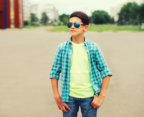Portrait of teenager boy wearing sunglasses and shirt in the city