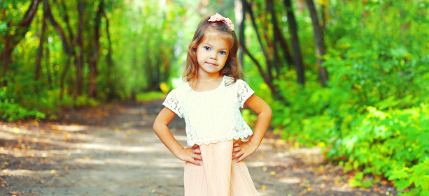 Portrait of little girl child in sunny summer park