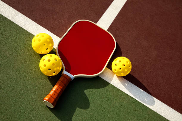 Pickleball Paddle and Balls on a Outdoor Court This is a photograph taken outside of a pickleball paddle and balls on a outdoor court pickleball equipment stock pictures, royalty-free photos & images