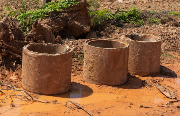 istock Old broken concrete cement pipe in grass,  Old concrete pipes, Cracked and deteriorated sewer pipes are left or placed on the ground. 1388270136