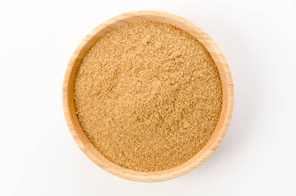 istock Powdered brown sugar in on wooden bowl on white background 1388271111