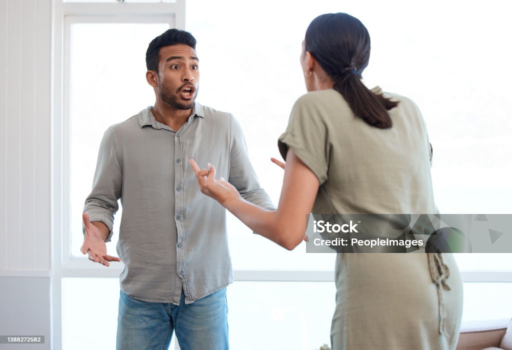 Shot of a young couple looking frustrated and arguing at home Protect me from what I want Arguing Stock Photo