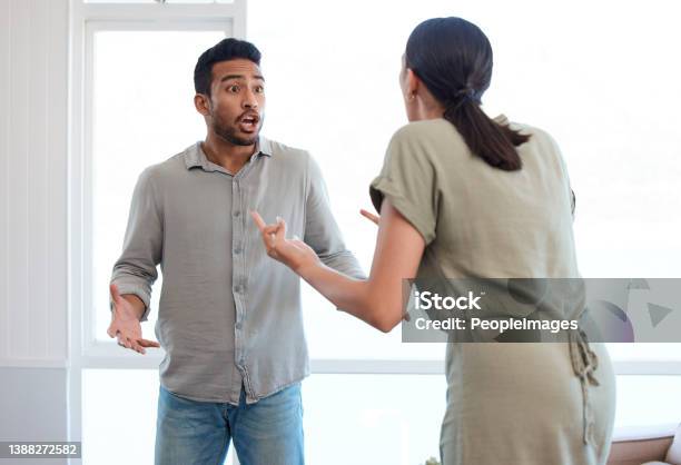 Shot Of A Young Couple Looking Frustrated And Arguing At Home Stock Photo - Download Image Now