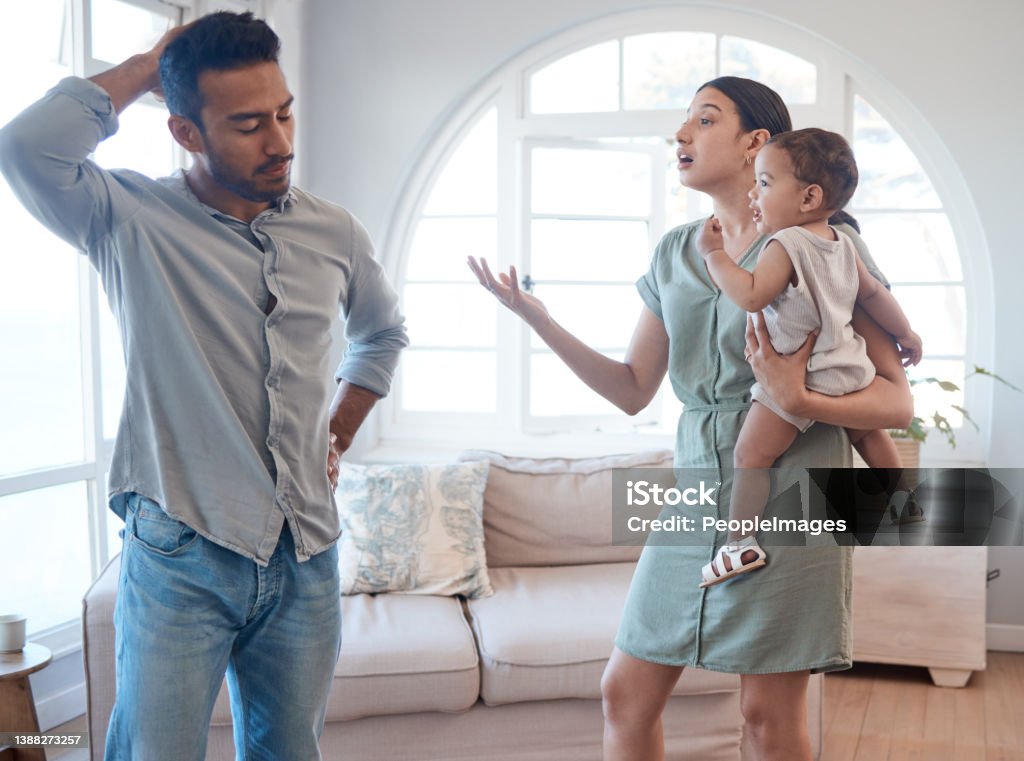 Shot of a young couple looking frustrated and arguing in the lounge at home With a weak husband, who needs enemies? Couple - Relationship Stock Photo
