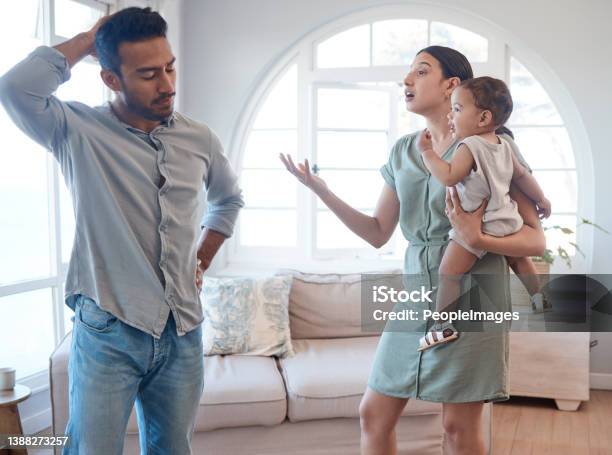 Shot Of A Young Couple Looking Frustrated And Arguing In The Lounge At Home Stock Photo - Download Image Now