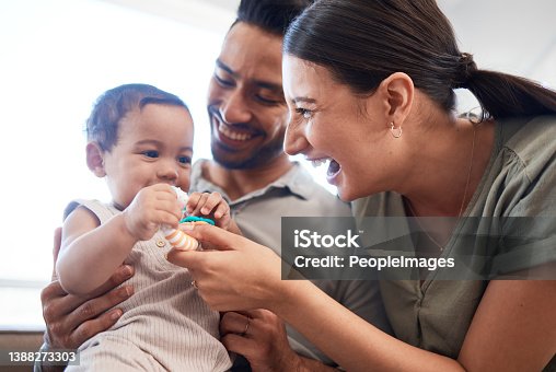 istock Shot of a young couple bonding with their baby girl on a sofa at home 1388273303