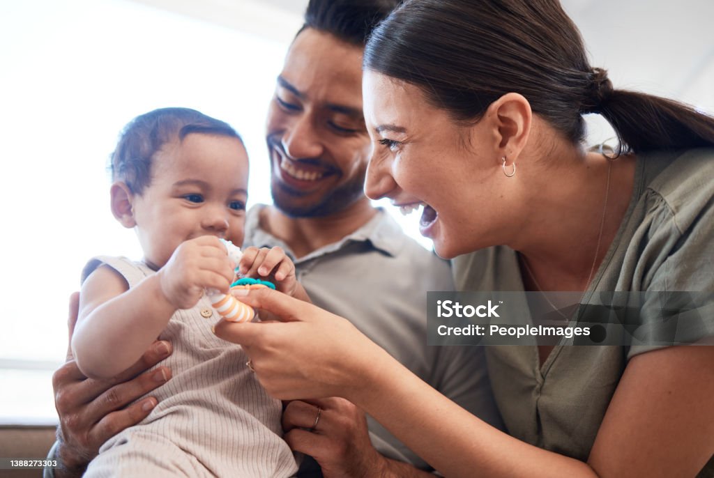 Shot of a young couple bonding with their baby girl on a sofa at home We were gifted with a perfect little girl Family Stock Photo