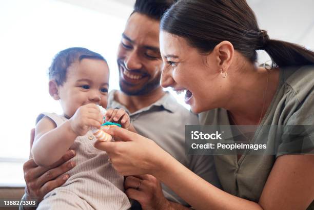 Shot Of A Young Couple Bonding With Their Baby Girl On A Sofa At Home Stock Photo - Download Image Now
