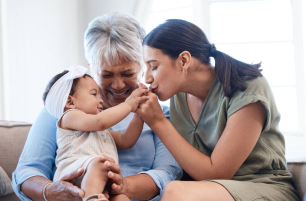 Shot of a mature woman bonding with her daughter and granddaughter on the sofa Happiness starts with happy wives! grandmother child baby mother stock pictures, royalty-free photos & images