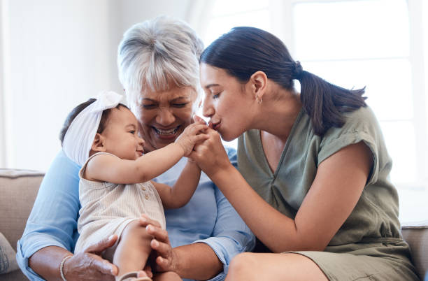 Shot of a mature woman bonding with her daughter and granddaughter on the sofa Happiness starts with happy wives! mom grandma baby stock pictures, royalty-free photos & images
