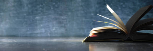 istock Open book, hardback book on wooden table on dark background. Back to school,education,reading. Copy space 1388275063