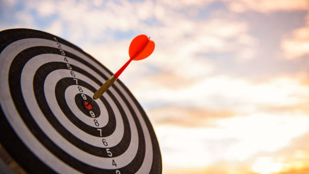 コンセプトとしてのビジネスマーケティング。ダーツボードターゲットのターゲットセンターでヒット赤いダーツの矢印は、中央にヒット。 - target dart shooting business ストックフォトと画像