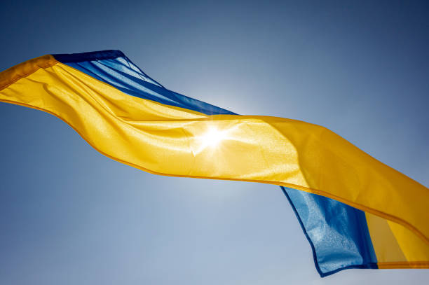 National flag of Ukraine National flag of Ukraine waving outside on a wind facing the bright sky and the Sun ukrainian language stock pictures, royalty-free photos & images