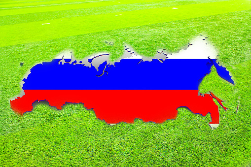 Defocus image blurred Flag of Russia on green grass field. Relationship between Ukraine and Russia concepts.