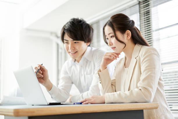 asiatischer geschäftsmann, der ein meeting hat, indem er auf einen computer schaut - laptop young men teaching business meeting stock-fotos und bilder