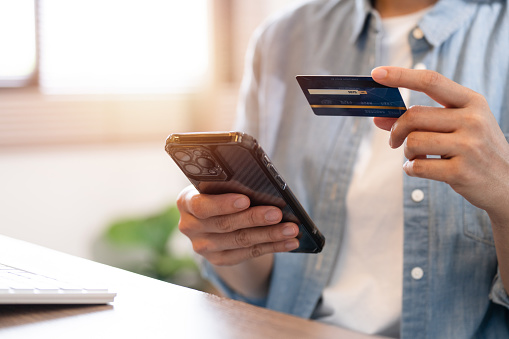 Woman holding credit card and using smartphone at home, businesswoman shopping online, e-commerce, internet banking, spending money, working from home concept