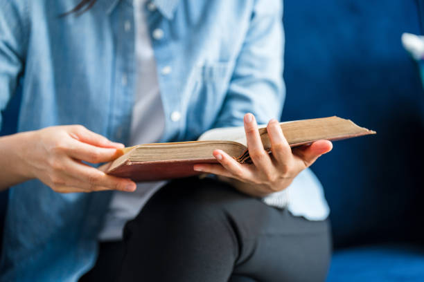 istock Close up Woman hand open book and reading for education 1388295216
