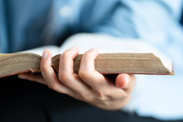 istock Close up Woman hand open book and reading for education 1388295219