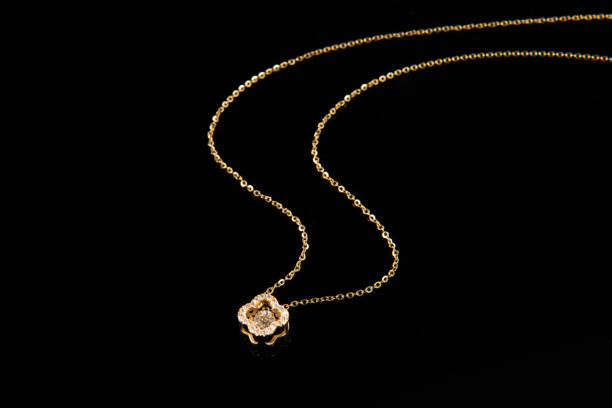 istock Golden chain necklace with diamond pendant on black background 1388297024