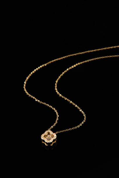 istock Golden chain necklace with diamond pendant on black background 1388297027