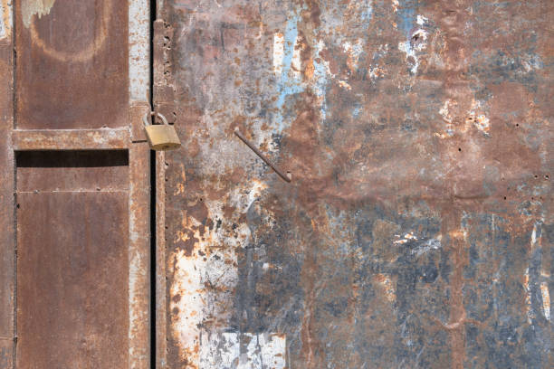 istock Padlock on old and rusty metal door. 1388298046