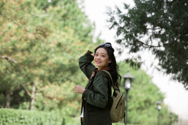 A young female college student looking back and smiling in a park - stock photo stock photo