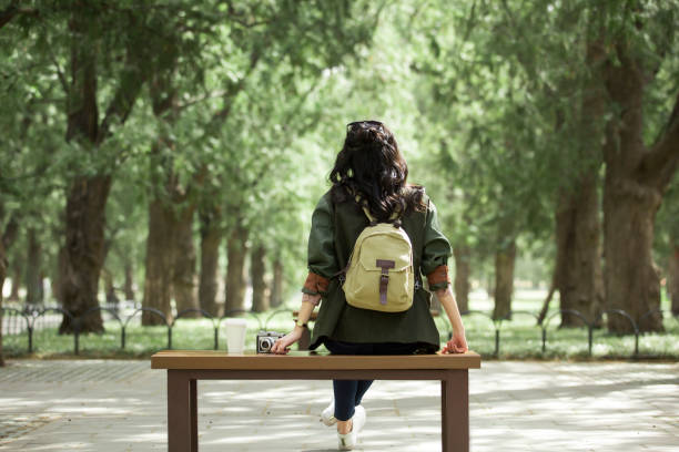 Young female photographer Sitting and resting on bench - stock photo stock photo