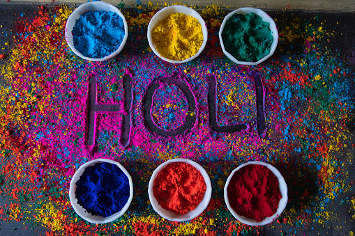 Handwritten holi on coloured background with use of selective focus