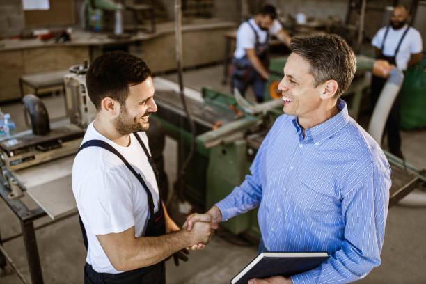 istock Happy manager shaking hands with manual worker in a workshop. 1388309853