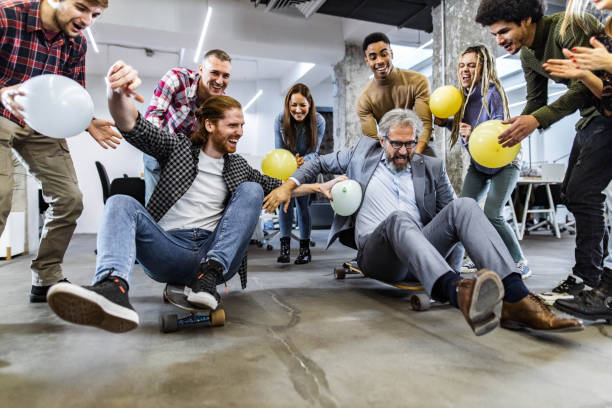 istock Cheerful freelancers having fun during skateboard competition at casual office. 1388310718