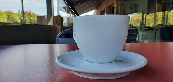 cup of coffee with milk on a table in a terrace concept of relaxation