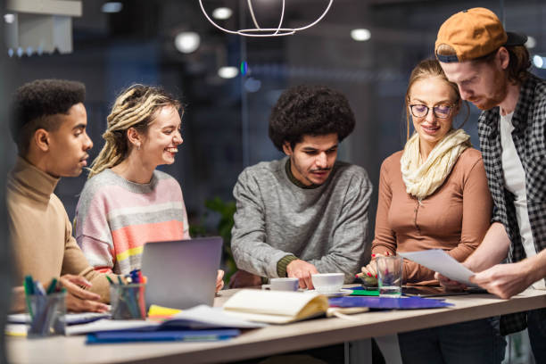 istock Group of young freelancers working on plans at casual office. 1388310766