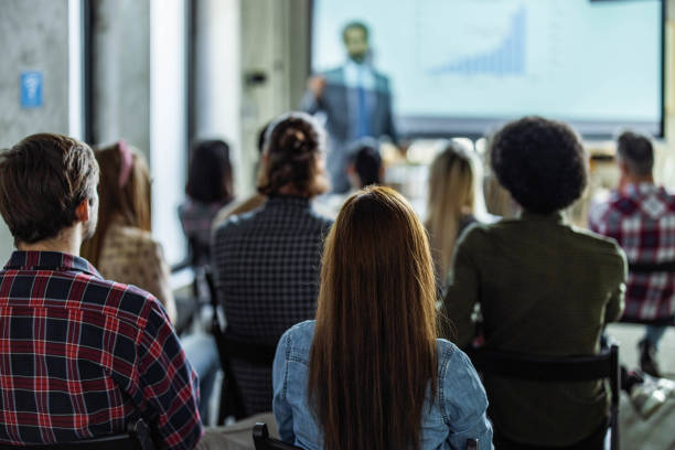 istock Back view of creative people on education event in the office. 1388310981