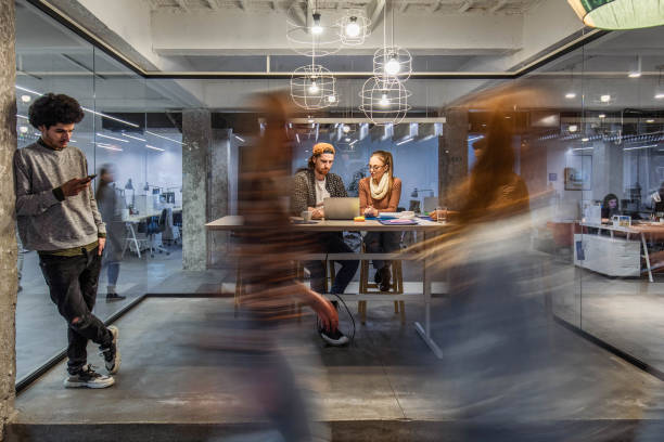 istock Young creative people working in the office among people in blurred motion. 1388311017