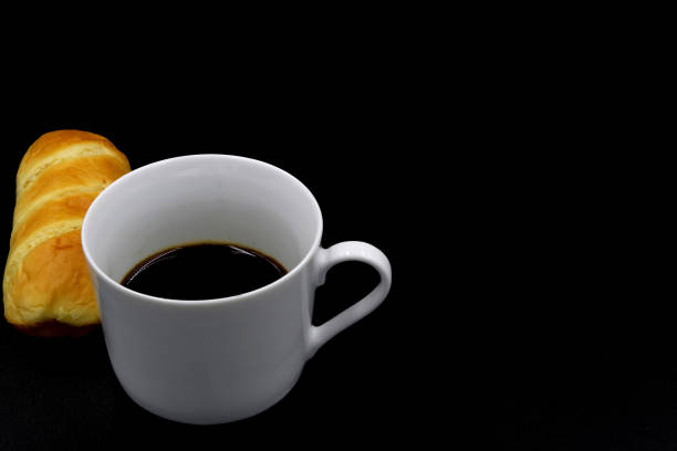 istock Butterbread next to a cup of coffee with a black background 1388311038