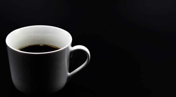 istock Mug of coffee on a black background 1388311088