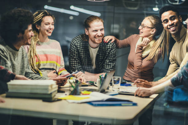 istock Cheerful start up team talking while having a meeting in the office. 1388311100